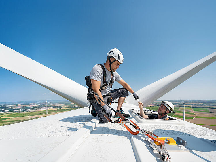 Zwei JUWI-Mitarbeiter aus der Betriebsführung oben auf der Gondel einer Windkraftanlage.